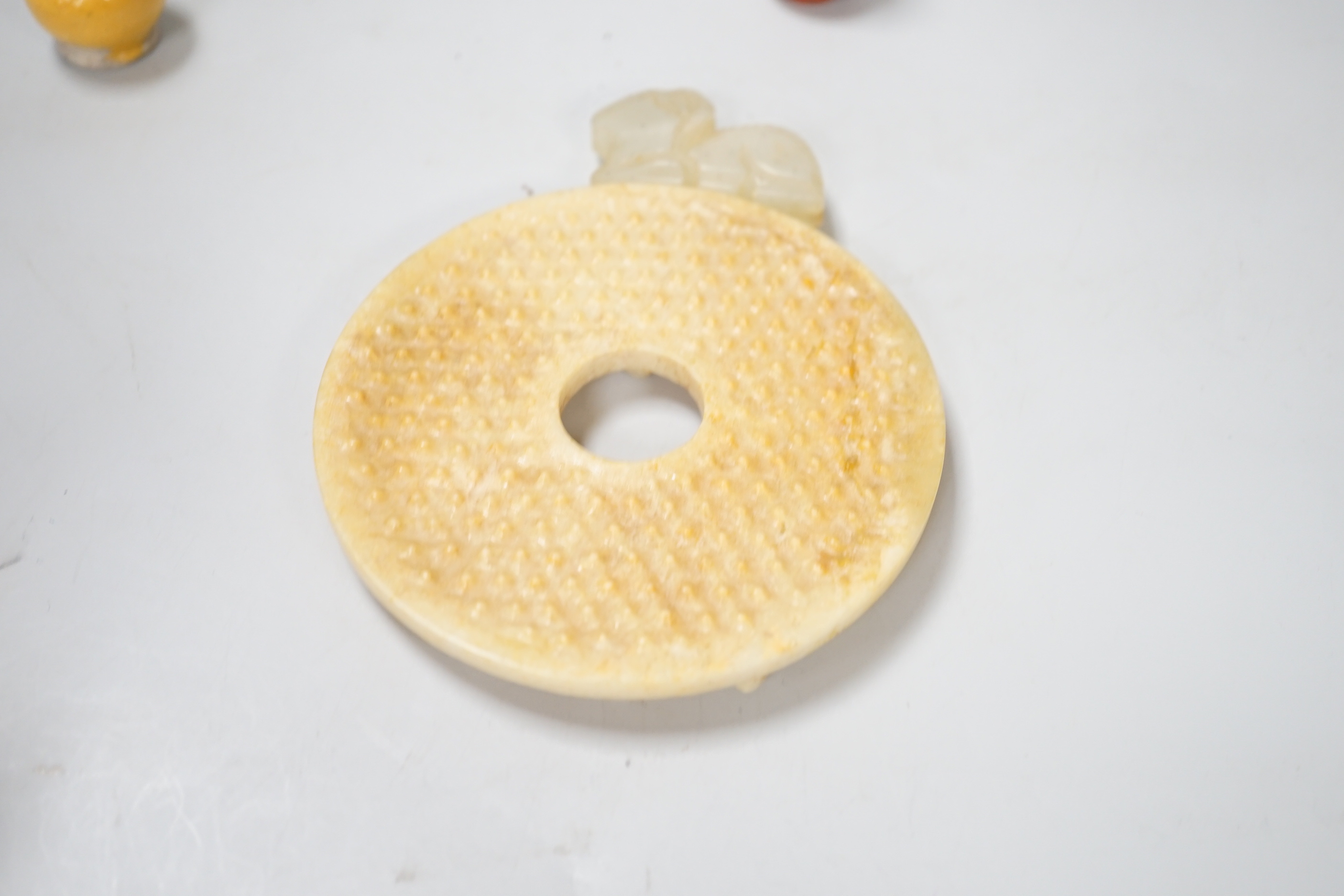 A group of Chinese small ceramics and a hardstone bi disc- 10.5 cm diameter
